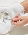 Girl wearing a Glitzy Glove jewelry polishing mitt and cleaning a sterling silver James Avery heart necklace. 